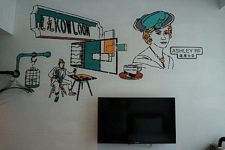 ベットと反対側、テレビの上の壁にもお洒落な絵が。九龍という文字の看板がレトロです。