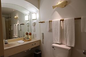 こちらはバスルーム内。バスルーム内も白をベースに、ナチュラルカラーでまとめられています。籐の籠やウッドのタオル掛けがリゾートの雰囲気を出しています。