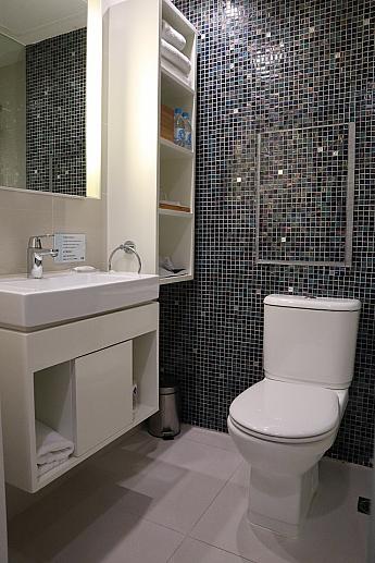こちらは浴室内の様子。濃いブルーのグラデーションタイルは清潔感と落ち着いた雰囲気をアップしています。バスタブはなく、シャワーブースが設置されています。