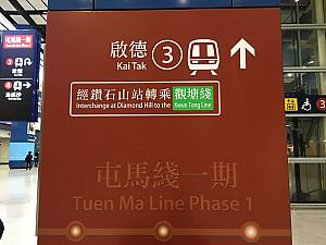 大圍（タイワイ）駅に来ると、あちらこちらでこんな表示を見かけます。東鐵線はこちらへ、屯馬線はこちらへ、と出ていますので啟德へいく場合は屯馬線へ行ってください。ちなみに香港の電車は路線ごとに色分けがされています。屯馬線は茶色で記されていますので、見つける際の目安にしてくださいね。