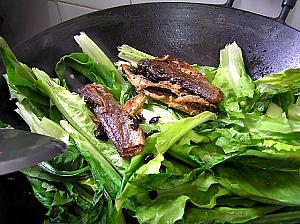 4. 油麦菜、鯪魚とのこりのトウチー、塩、水を加えて軽く混ぜたら、ふたをして3-4分加熱する