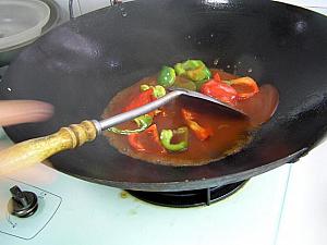 6. 中華なべに油を熱し、赤・青パプリカを炒め、合わせておいた酢豚あんを加えて混ぜる。