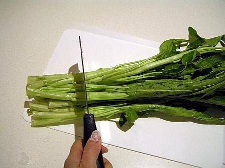1. 通菜は根に近い固い部分を切り落とし、食べやすいように茎と葉に分けて切る 