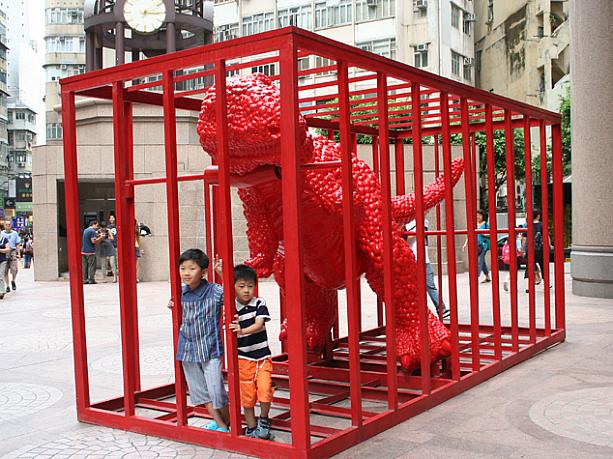 『メイド・イン・チャイナ』と書かれた赤いゴジラは、なぜか檻の中。