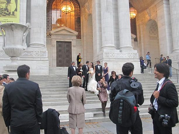図書館入口で結婚式の記念撮影をするカップル。
