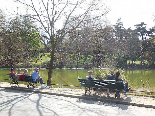 池の周りのベンチでは日向ぼっこをする人たちがのんびりと語り合います。