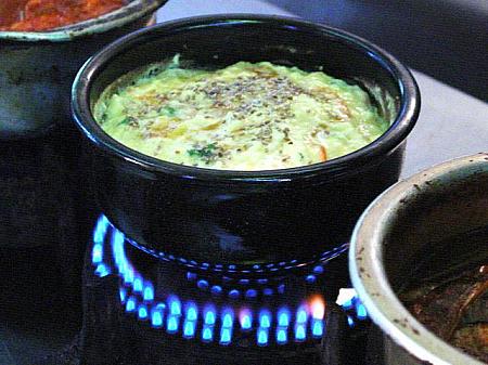 ２． 水が沸騰してきたら卵、野菜、出し汁などを混ぜたものを鍋に流し込む。