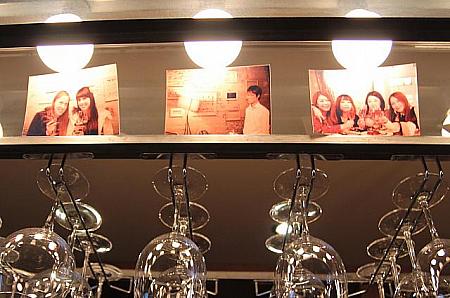 お店に来てくれたお客さんの記念写真が、ワイングラスと一緒に飾られています