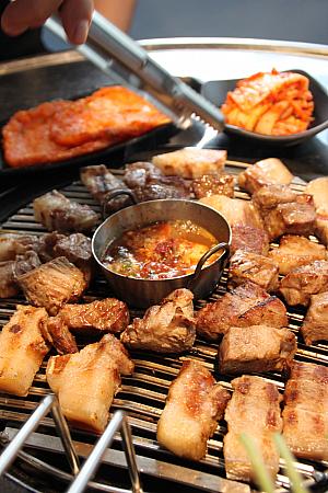 テーブルで焼きあがったお肉にメルチョッ（カタクチイワシの塩辛）をつけて、お好みでサンチュにのっけて