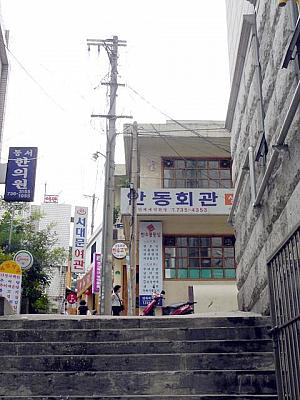 坂を上ってトルダムキルの入口、京郷新聞社の十字路へ。
路地の上をのぞくと、古い建物が見えます。