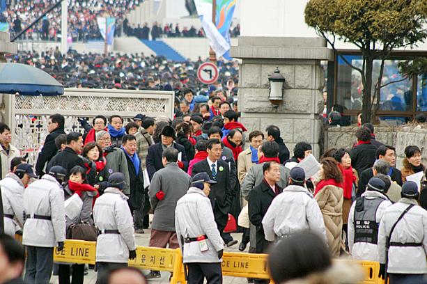 就任式の行われる国会前の広場の中には、一般の人は引換券が無いと入れません。赤や青のマフラーは引換券と一緒に貰えるもの。それにしてもすごい人っ！