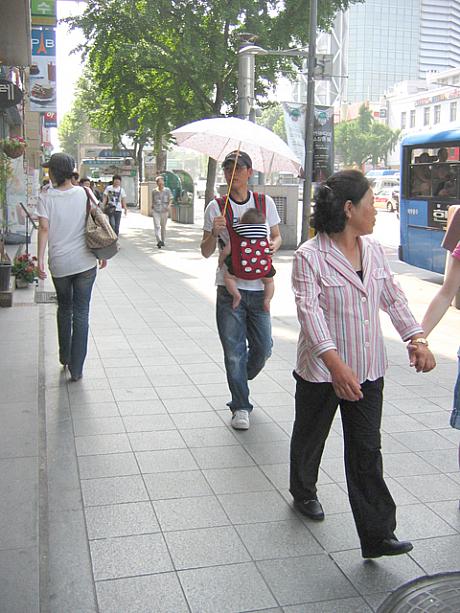 日傘をさした男性が！？と思ったら、抱っこした赤ちゃんを陽射しから守っていたんですね〜＾＾　ソウルでは以前よりも日傘を使う人が多くなったようですよ！