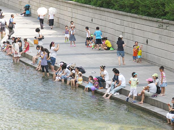 川辺に座り、足を水につけて涼む人々の姿は夏の定番の光景！大人も子供も楽しそうですネ＾＾