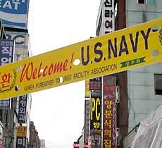 アメリカ海軍歓迎の横断幕がはためく、草梁外国人商店街の入口。 -草梁外国人商店街にて