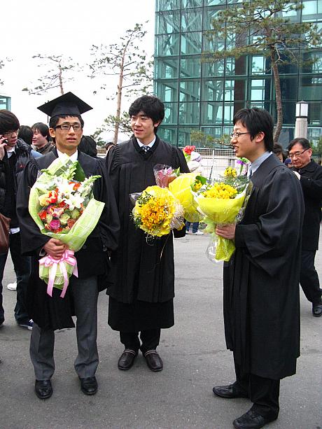これが韓国の大学の卒業生スタイル。黒いガウンに四角い帽子、そして手にはお祝いに貰ったカラフルな花束?！