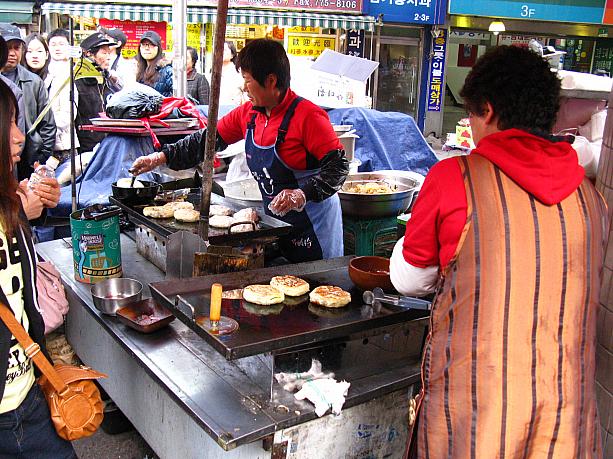 あっ、コレは屋台フードの定番、ホットッですね！モチモチとした生地の中に、蜜やナッツの入った甘いおやつ系の食べ物です。うーん、それにしても普通のホットッより少し大きめで、何だかモコモコとふくらんでいるような・・・