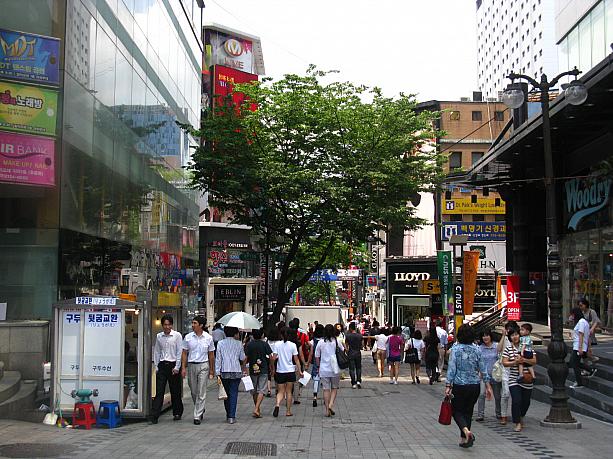 こちらは明洞(ミョンドン)。地下鉄４号線ミョンドン(明洞)駅の６番出口を出て、左に向かって伸びているメインストリート「明洞中央通り」を見たこの場所、ファッションビル「ミリオレ明洞」のちょうど前辺りです。ここから、