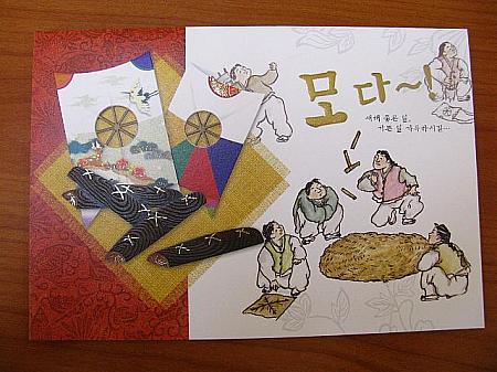 新年の遊び、凧揚げやユンノリ（韓国の双六）をして遊ぶ人々。「모다～（モダー）！」はユンノリで一番良い目のことだそう。（900）