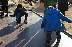 先がとがったこまを氷の板や道に立てて力いっぱい回した後、棒に糸をかけて作ったムチで一生懸命たたいて長時間回します。大人も子供も夢中。