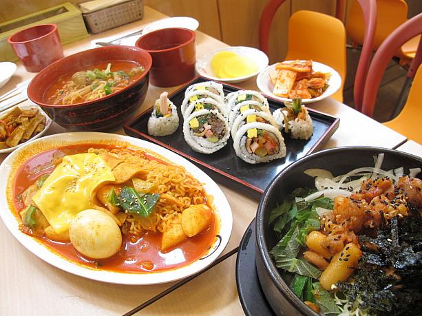 今回注文してみたのは、チジュラッポッキ（ラーメン+トッポッキにチーズトッピング）、モドゥンキンパッ（いろんな具が入ったキンパッ）、チャンポンラミョン（韓国のチャンポンは普通、赤くて辛いんです）、メウンチキントッパッ（辛いチキン丼）。B級グルメだけど、並べてみるとなんとも豪勢！