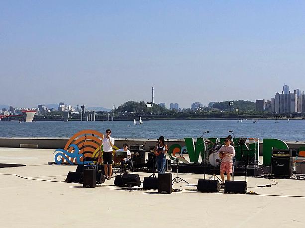 こちらはＷＩＮＤステージ。ピクニック気分でＢＧＭのように聞けるアコースティック音楽が得意のアーティストが漢江をバックに気持ちのよい音を出していました。