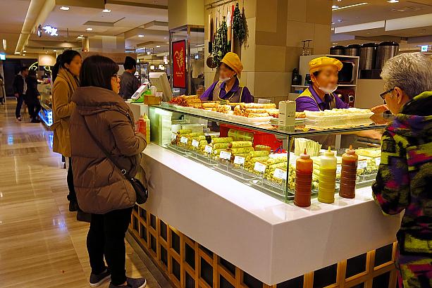 お買い物中に小腹が空いたらちょっとつまめる軽食のお店も。この手作りオムッ屋さんは特に人気。デパ地下なのに、屋台のように立ったままオデンやハッバー（練りもの天ぷら）をつまむなんて、ちょっと不思議なかんじ！