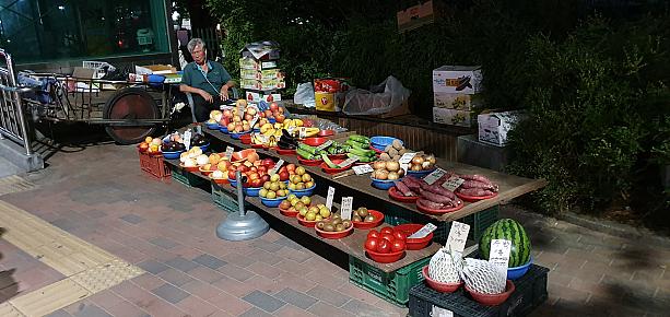 路上で野菜や果物を売りながら居眠り中～。こんなにぎやかな街角でも、風情あるお店がほそぼそと販売中ですね～