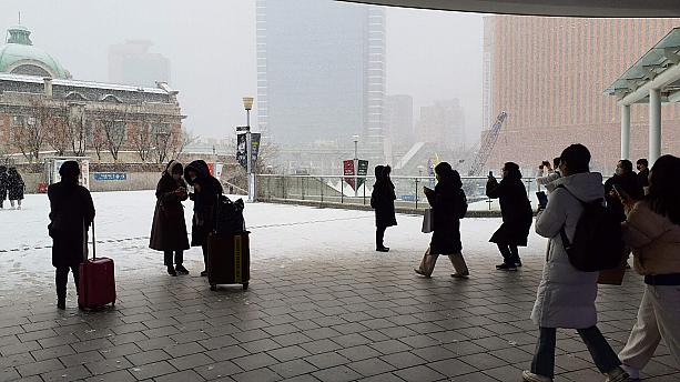 地下鉄や国鉄から降りてきた人たちも、皆、初雪を喜んで写真撮影しています。