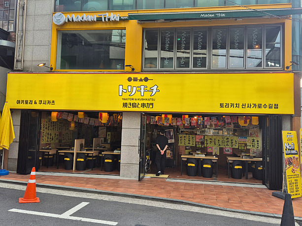 お店の外観。黄色い看板と白抜きされた日本語の店名が目立ちます。