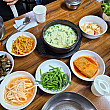 メニューを注文するとケランチム（韓国風茶わん蒸し）と共にカジナムル（ナスナムル）、コンナムル（豆もやしのナムル）、プチュ（ニラ）、ムセンチェ（大根ナムル）、サンチュ（サニーレタス）などのパンチャン（おかず）類が出てきます。