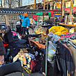 山積みにされた服が大安売りされ、品定めに余念がない人たちの様子。