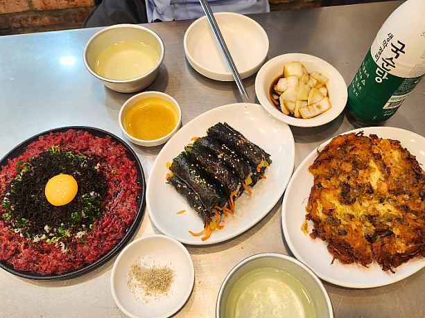 お店に入って、ビンデトッ（緑豆チヂミ）、キンパ、そしてこちらも名物のユッケを注文。もちろんお酒はマッコリで。