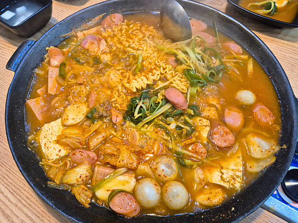 ラーメン、スパム、ソーセージ、ベーコン、牛肉のミンチ、マンドゥ（餃子）、オムク（オデン）、春雨、豆腐、お餅など具材盛りだくさんのプデチゲ。おいしそう～。