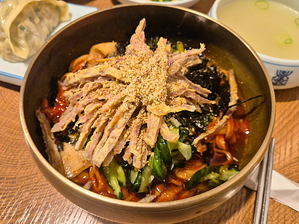 ビビンククス（ピリ辛混ぜ麺）。生麺に、ピリ辛ダレ・新鮮な野菜・薄切りの肉を合わせた一品。コシのある麺と甘辛ソースの相性が抜群です。