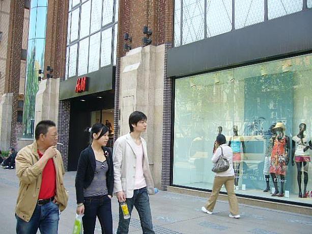 上海市内を東西に走る「淮海中路」は、地元の若い子に人気のお買い物ストリート。こちらは１年前にできたスウェーデン発カジュアルファッションH&Mの前。店頭に並ぶ商品は、すでに夏物！