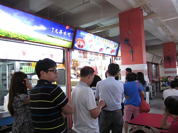 暑い空気が流れる中、奥まで行くと、ありました！長い行列。Hong Kong Soya Sauce Chicken Rice & Noodle、こちらは#02-127にあります。柱にある巨大扇風機がこれほどありがたいと思ったことはありません。。。