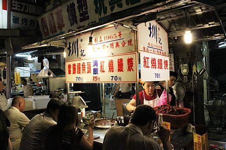 この屋台の後ろの細い道にテーブルが並べられています