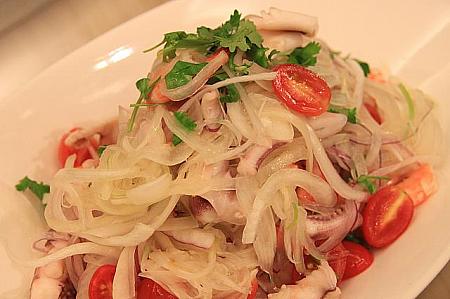 【泰式沙拉（タイ風サラダ）】<br>新鮮な玉ねぎとトマトの甘さが引き立つ酸味の効いたドレッシング。エビやイカもふんだんに入っています