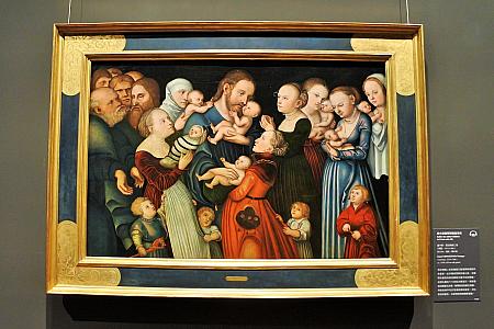 子供たちを私の元へ来させなさい<br>
ルーカス・クラナッハ（子）／1540年頃<br>
中央にいるイエスが、小さな子供たちを祝福している様子を描いたこの作品は、聖書のマルコによる福音書の中の一節を表現したもの。子供たちがイエスのヒゲや髪を引っ張って遊んでいる様子を描き、子供たちの純真さやイエスの愛情に満ちた慈しみを表現しています。