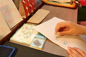 カウンター脇で熱心に何かをしている学生さん。のぞいてみるとスタンプで旅の思い出作り中♪