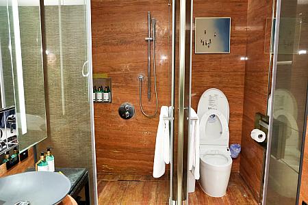 バスルームのオープンスペースに洗面台とバスタブ、シャワーブース、トイレがそれぞれセパレートに