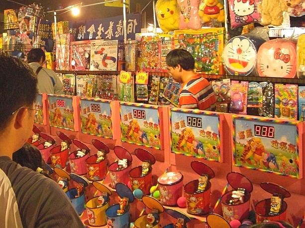 台湾名物の夜市には、大人も子供も楽しめるゲームがいっぱい。これはパッコンパッコンと開いたり閉じたりするゴミ箱にボールを投げ込むゲーム。小さい子が夢中になってます。