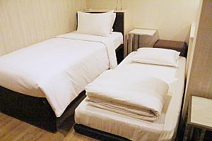 【ヨミホテル(優美飯店)】シングルとクイーンサイズのベッドが1台ずつ置いているトリプルルームは、エキストラベッドを1台入れて4人で泊まることも可能。どうしてもベッドを別々にして寝たいという方なら4人仕様でリクエストして3人で宿泊するのもありですよ～。