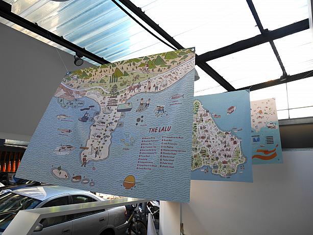 ギャラリーの店舗先に飾られているフラッグはいちばん手前が中国のLALUホテル、マカオにある島の地図、同じくマカオのドラマのロケ地の地図