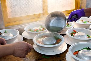 料理は会場脇の即席調理場で作られるのが一般的。次々と料理が並べられ、準備が整ったら、テーブルへと運ばれます。迫力満点！