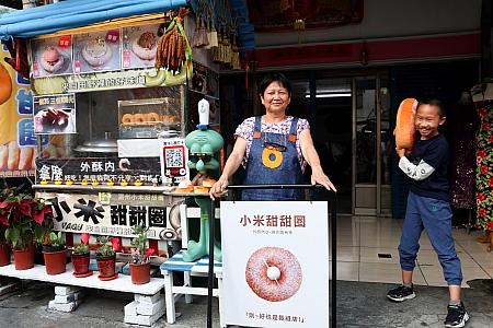 学生の作品である「小米甜甜圏」の看板とおかみと次期(？)店主。本業はお直し屋さんだから表裏異なるデザインに