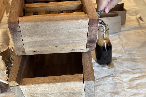 加熱し、味を調節したもろみを、ここで圧搾して、醤油をしぼり出します。横の蛇口からどんどん出てくるので、空の瓶に入れていきます。