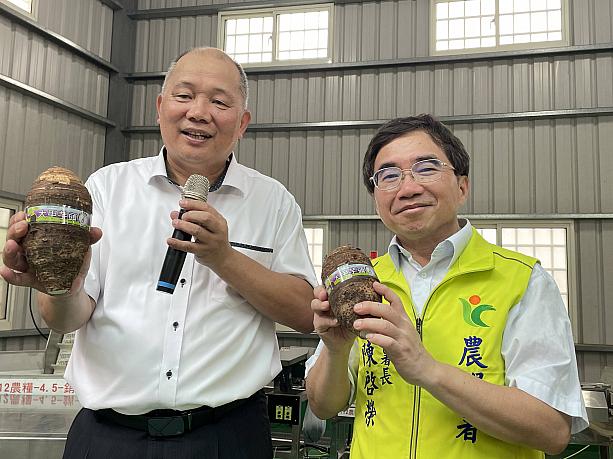 誇らしげに大甲のタロ芋を掲げる、左・大甲農會の黃瑞祥總幹事と右・農業部農糧署の陳啟榮副署長。タロ芋産業の変革と高度化を推進を目指してご活躍中！