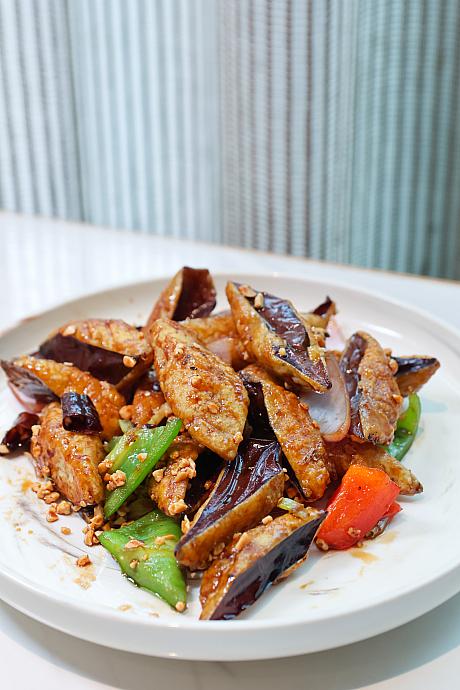 <b>皇朝風ピリ辛ナス(皇朝風味茄子)288元/份</b><br>薄っすらと衣をまとったナスはカラリと揚げられ、ひと口かじるとサクリ。次の瞬間にはとろ～んと実が飛び出します。ああ、これぞナス！日本産の薄皮で肉厚のナスを使っているから成せる技。そんなナスに絡めるのは甘×酸×辛が融合したタレ、仕上げにピーナッツを散らして香ばしさもプラスしてあります。ごはんのお供にもぴったりです。