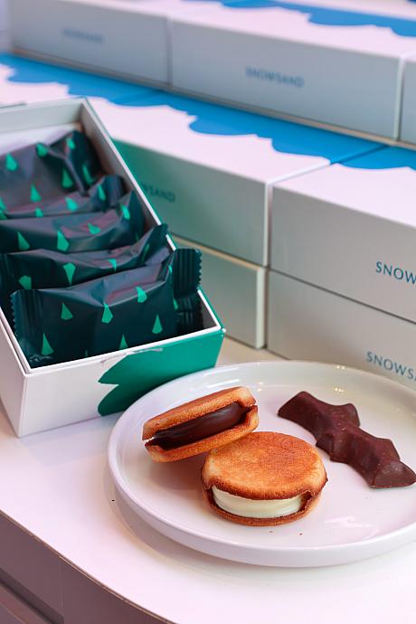 「SNOWS(スノー)」の看板商品「スノーサンド(SNOWSAND生巧克力夾心餅乾)」は生チョコレートをラングドシャでサンドしたサンドクッキー！いつも食べているラングドシャよりもザクザクだし、形状が柔らかい生チョコレートを守るように包んでいるのがかわいい♡